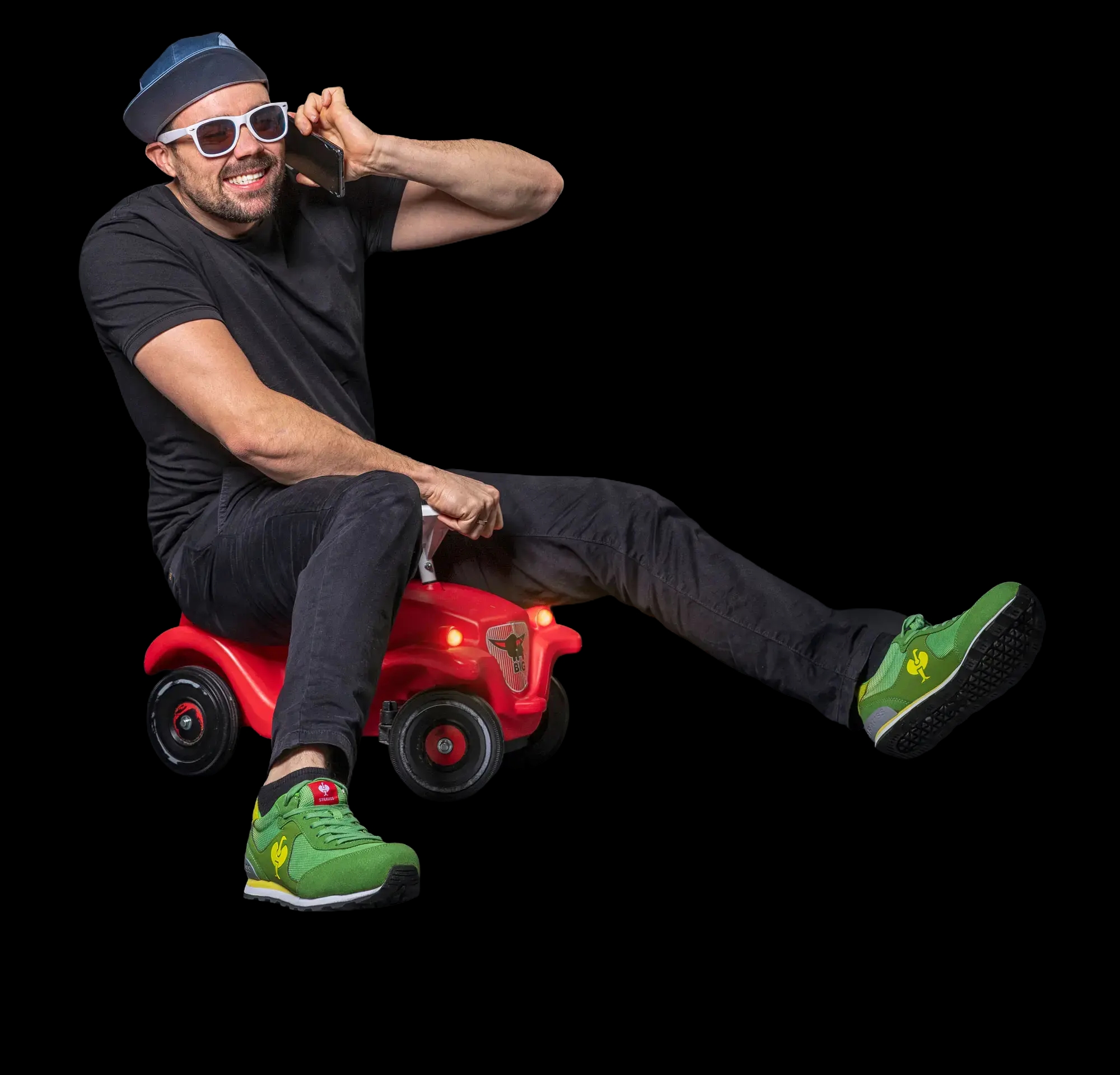 Manuel Volz von wkm mit Telefon auf einem roten Bobbycar