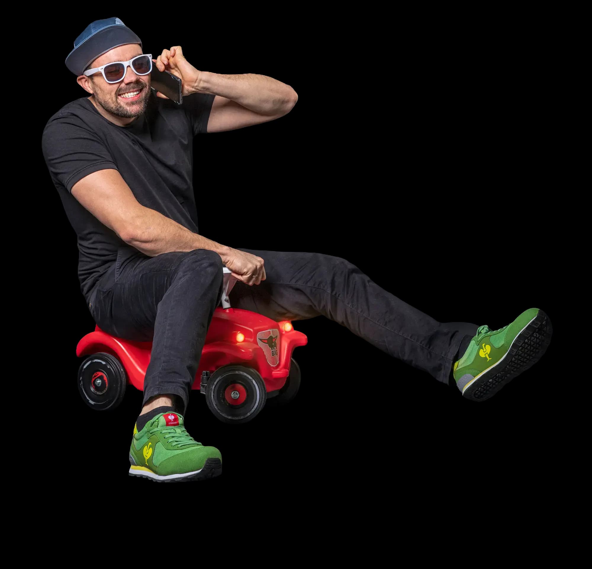 Manuel Volz von wkm mit Telefon auf einem roten Bobbycar